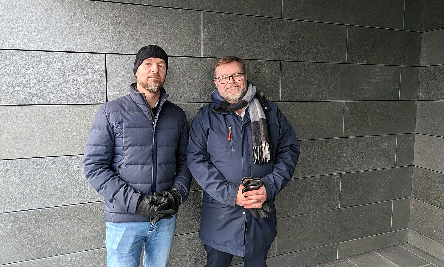 Two men standing in front of a wall of Altaskifer fastened with Fixad