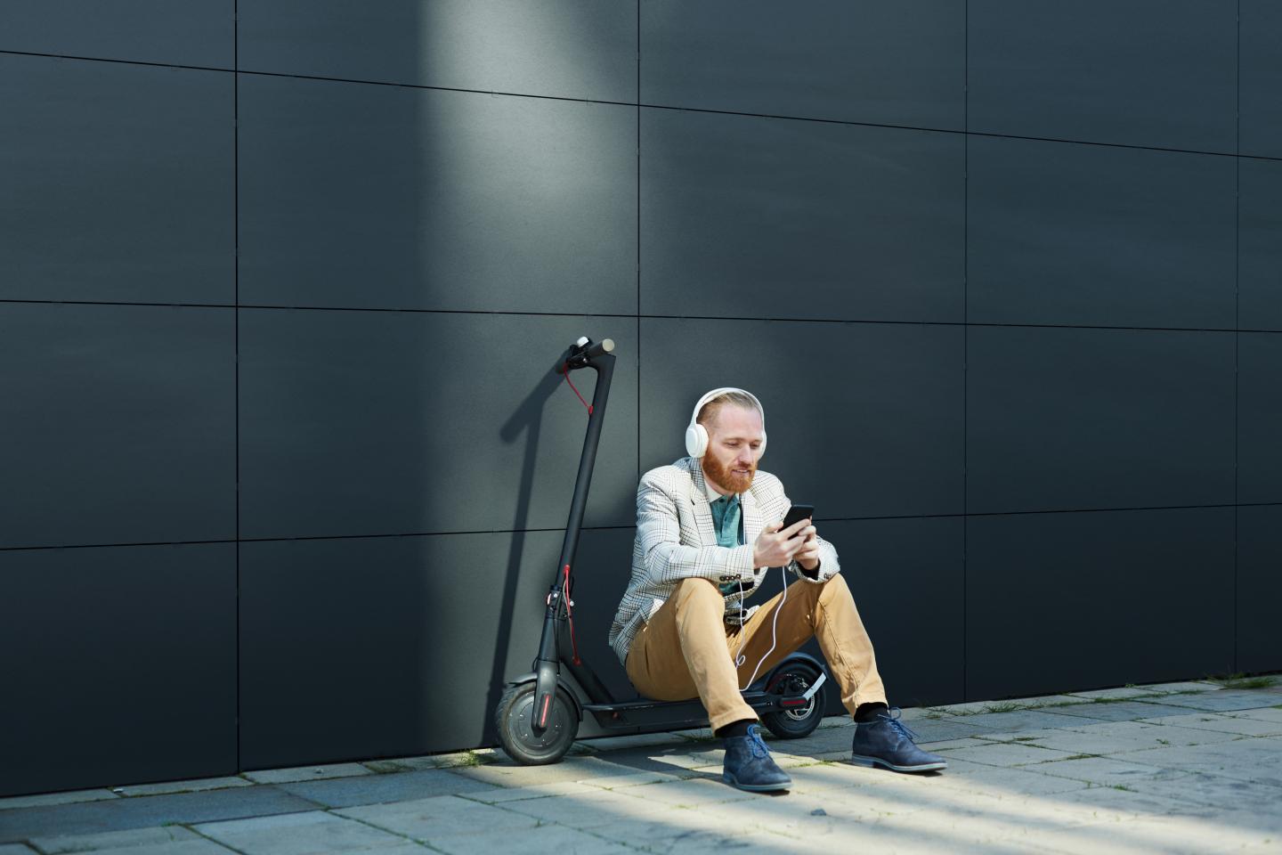 PErson sitter foran en vegg